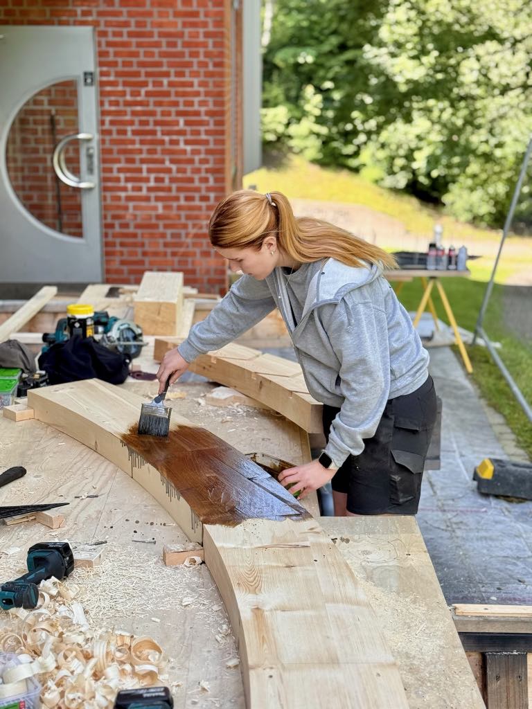 Jente beiser treverk til nytt vannhjul på Teknisk museum ved Akerselva